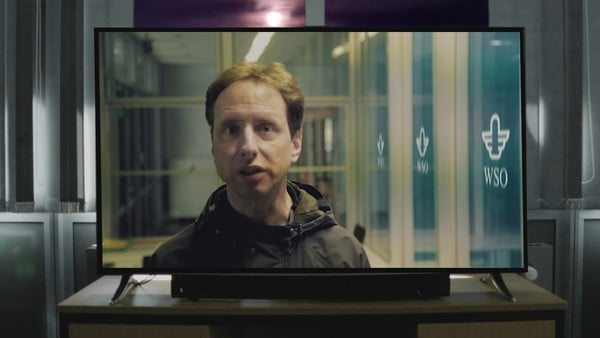 Ein Mann redet intensiv aus einem Fernseher heraus mit den Zuschauenden.
